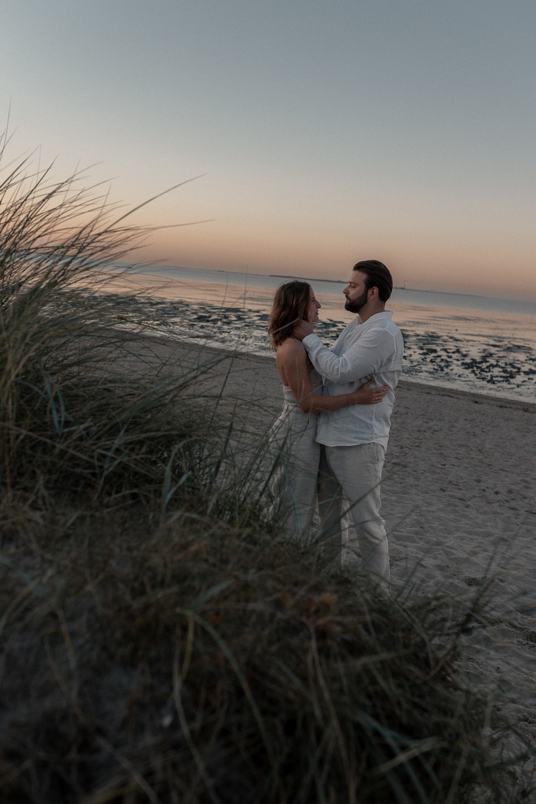 Paar am Strand vertraut im Sonnenuntergang